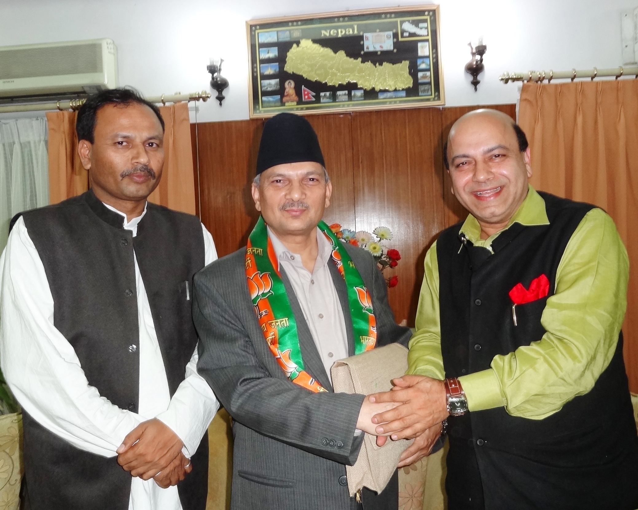 BJP Leader Shri Vijay Jolly presented a lotus scarf and BJP party literature to Nepal PM, Dr. Babu Ram Bhattarai alongwith Madhesi leader Anil Kumar Jha on April 24, 2012