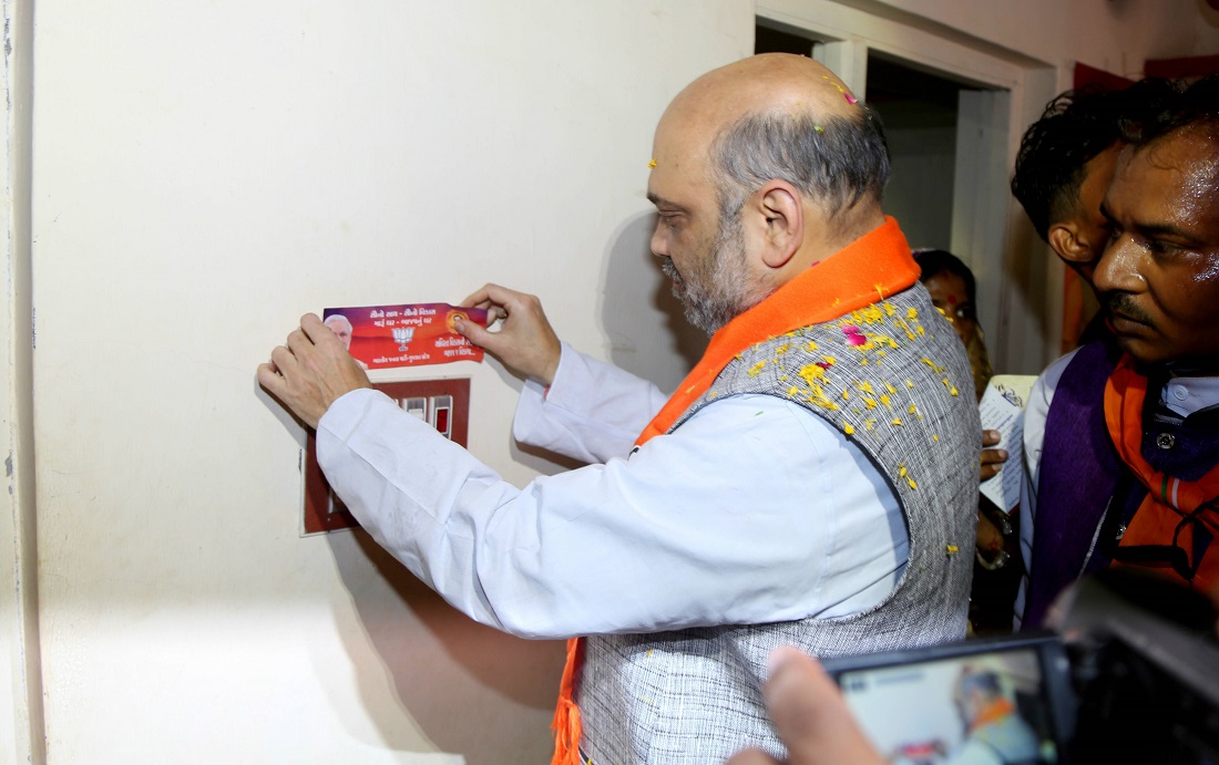  BJP President, Shri Amit Shah pasting sticker of Sabka Sath Sabka Vikas during door to door sampark at Devliya Village, Chhota Udaipur Gujarat on 31 May 2017.